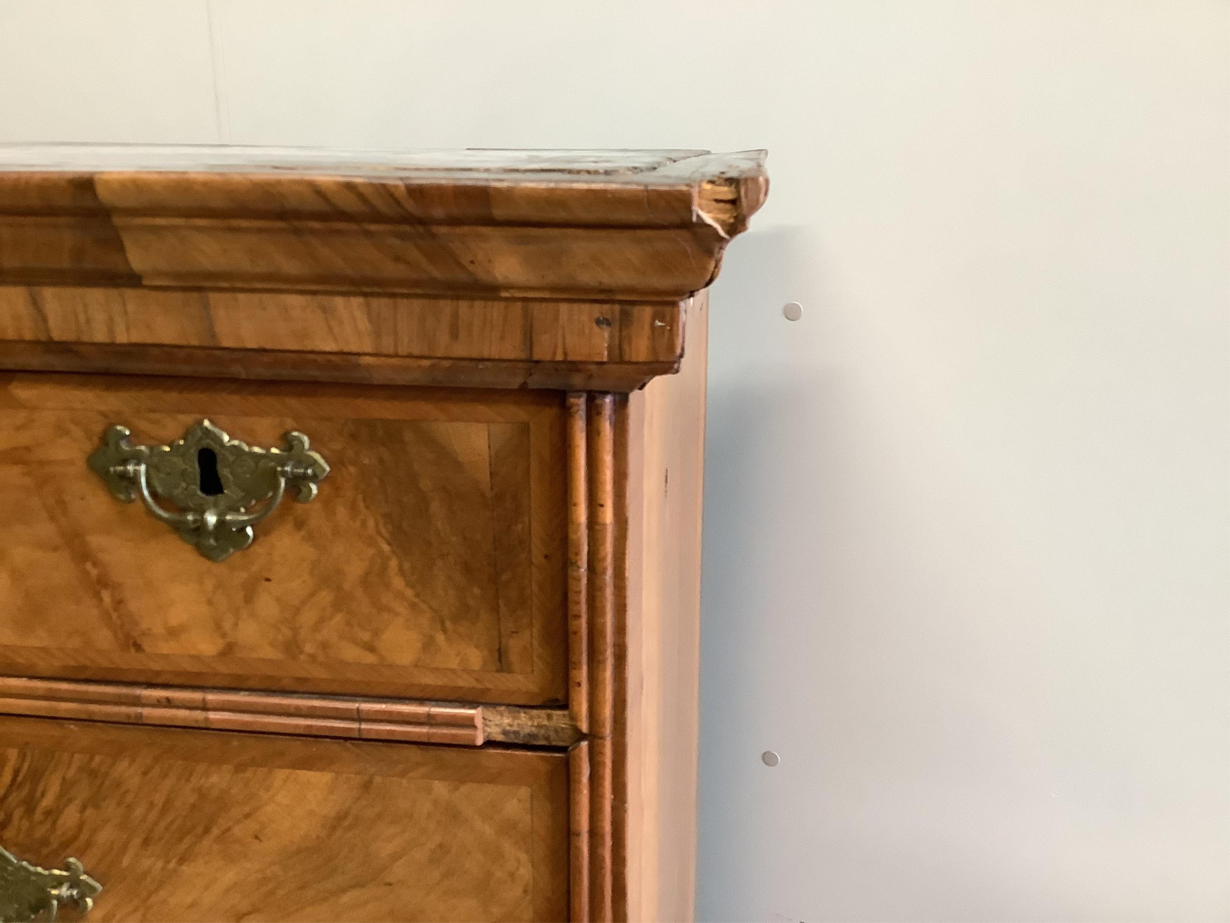 An early 18th century walnut chest on stand with later bun feet, width 106cm, height 147cm. Condition - fair